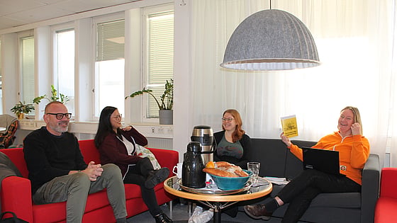 En grupp på fyra personer diskuterar kring ett fikabord. De pratar om foldern om krisberedskap