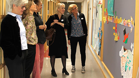 Rektor på folkhögskolan visar en utställning som kursen Migration och social hållbarhet har gjort